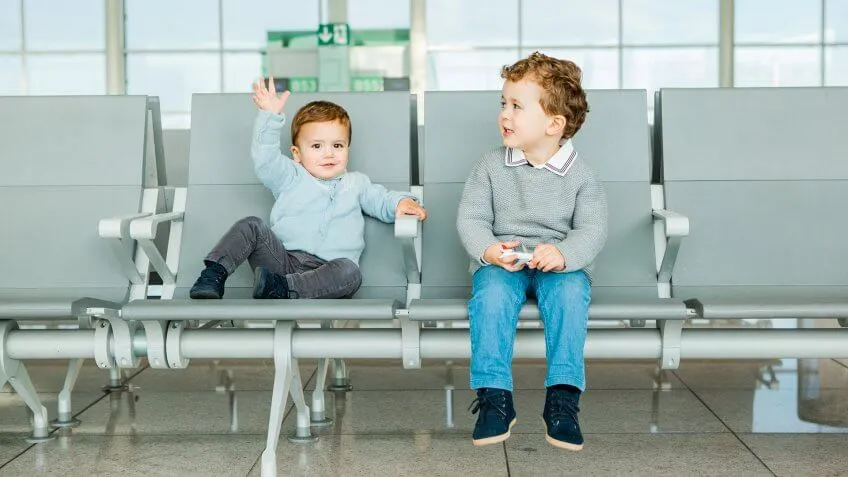 Children waiting near airport boarding gate.