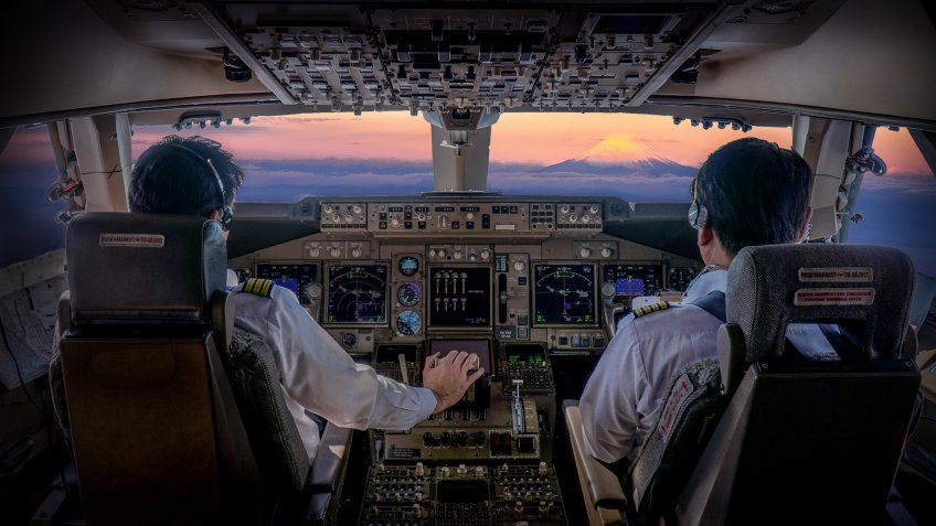 commercial airplane pilots flying at sunset