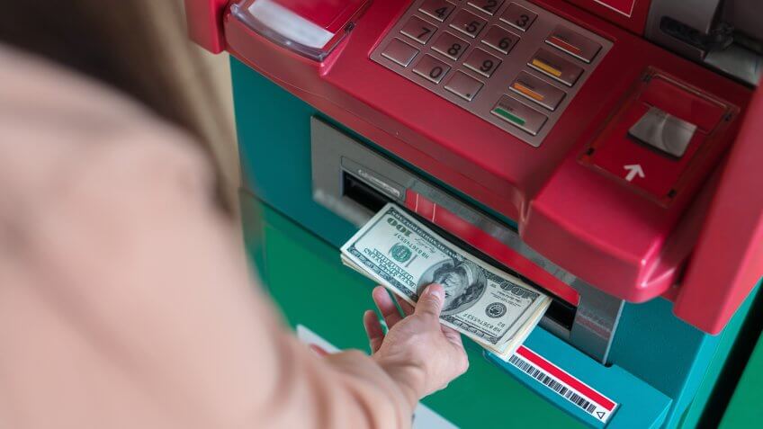 Top view of Closeup woman withdrawing the cash via ATM, business Automatic Teller Machine concept.