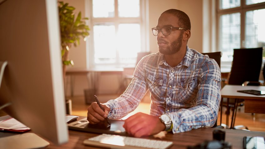 Freelance photographer sitting in his office and working.