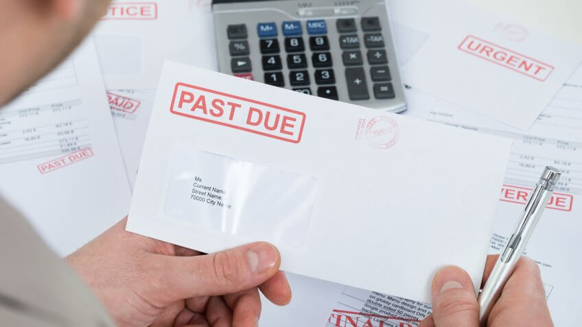man opening up past due late bills