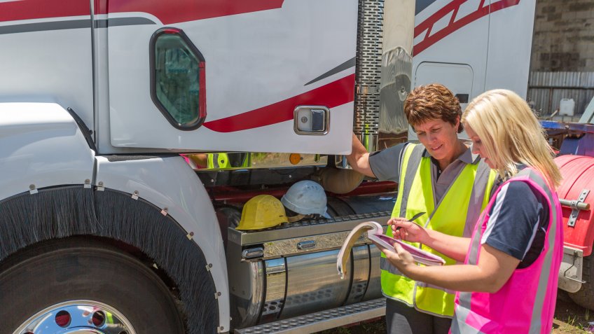 Empowered happy women working in the transport industry wearing high visibility clothing.