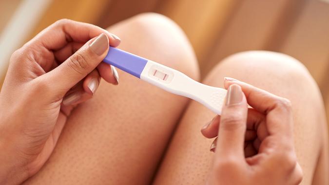 Cropped shot of a woman holding a pregnancy test that’s positive.