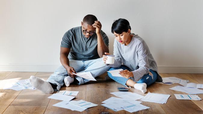 Couple-sitting-on-floor-managing-finance-documents