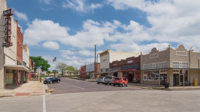 ENNIS, TX, USA-MAR 31, 2018:Historic vintage building, street at downtown Ennis cloud blue sky.