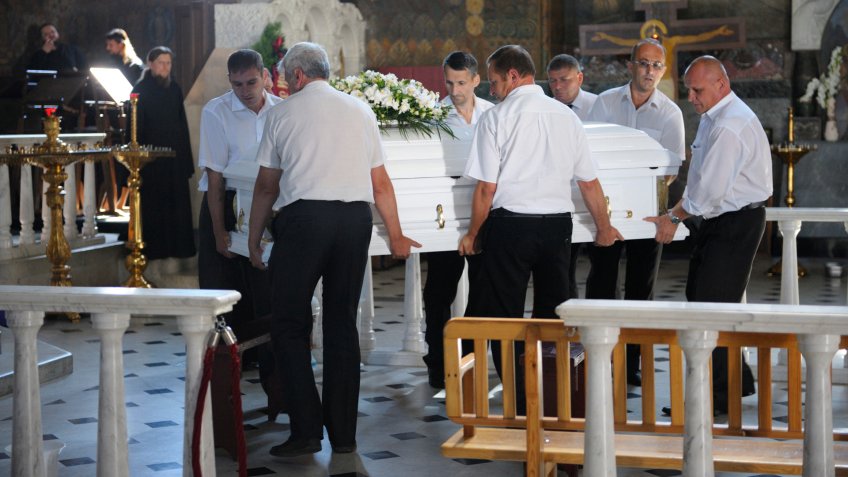funeral service workers carrying a casket