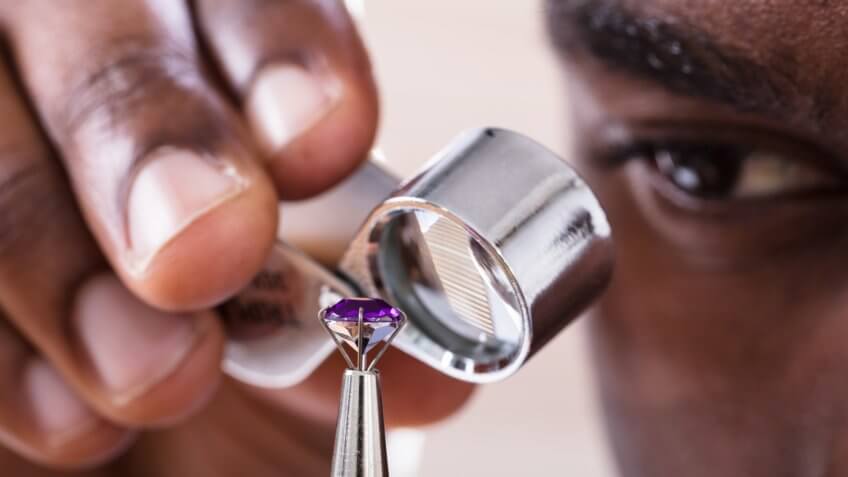 Jeweler Examining Diamond Through Loupe