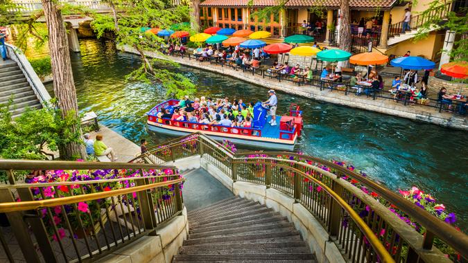 San Antonio, Texas, USA - April 14, 2013: Tourists riding in tour boat and eating at restaurants along The Riverwalk in San Antonio Texas.