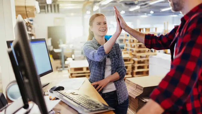 Photo of a coworkers celebrating success in printing factory.