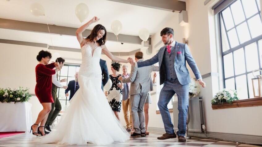 newlywed couple dancing with their guests on the dance floor