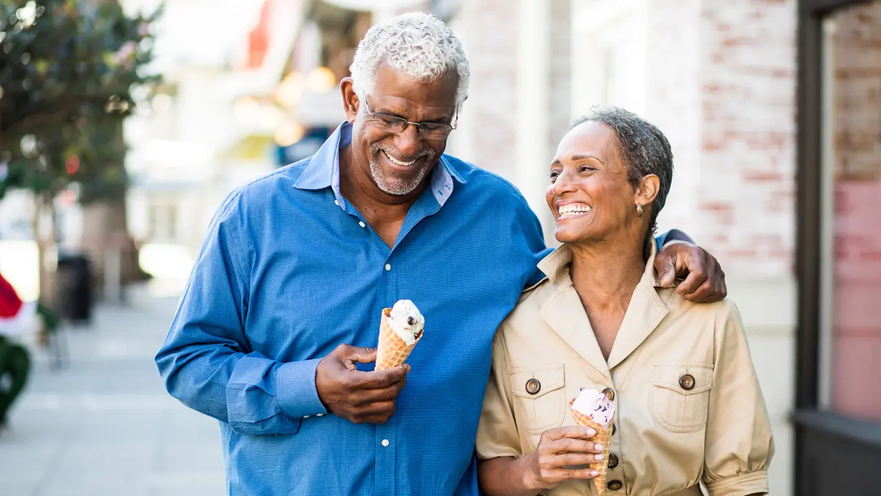 A senior african american couple enjoy an evening on the town with ice cream.