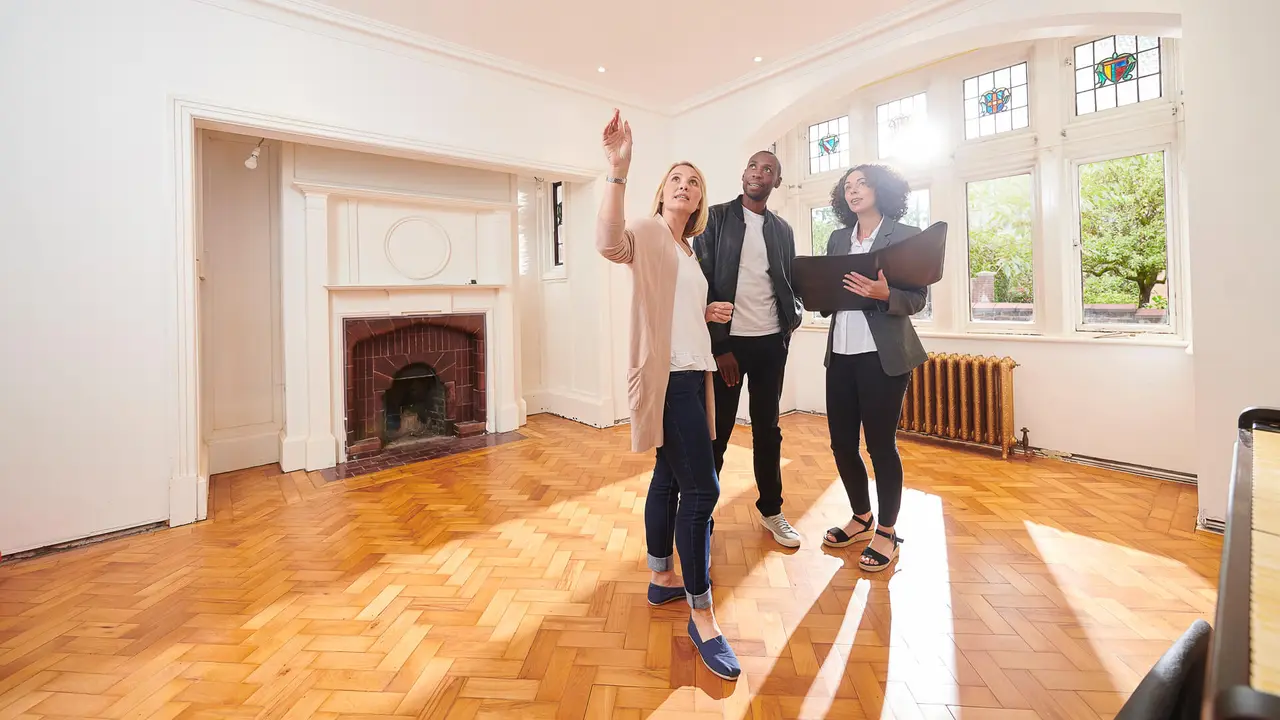 an estate agent shows a couple around a refurbished period home.