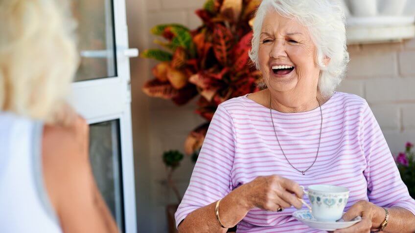 elderly woman laughing with her lady friend