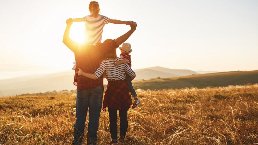 Happy family: mother, father, children son and daughter on nature on sunset.
