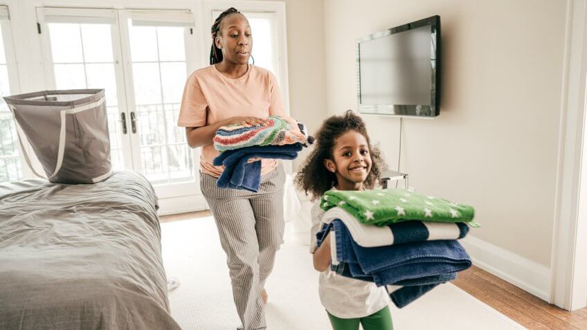 Daughter and mother folding clean towels.
