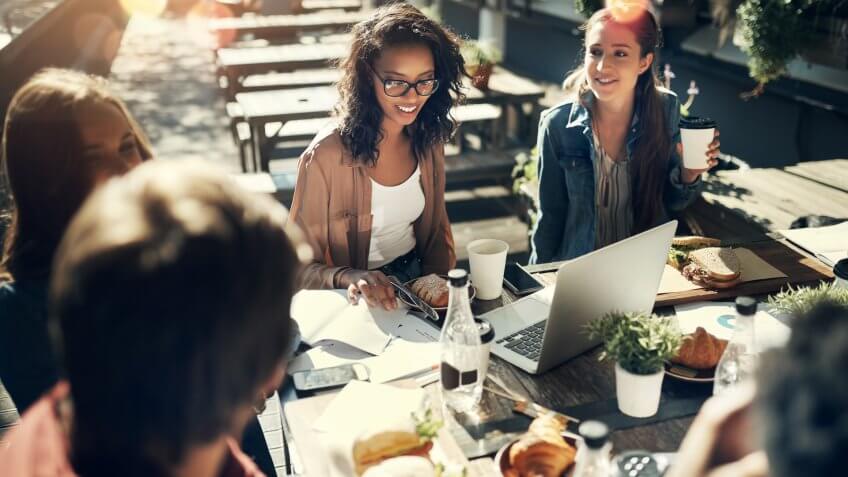 High angle shot of a group of creative employees having a breakfast meeting outside.