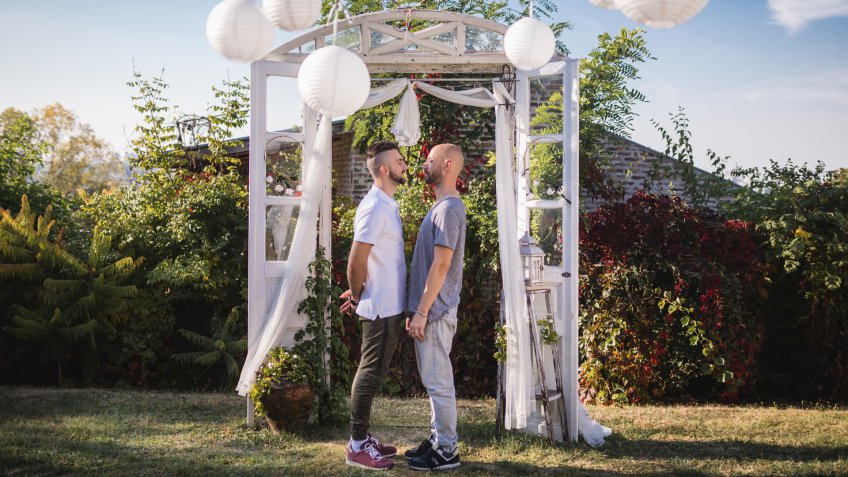Romantic gay couple standing on a wedding aisle