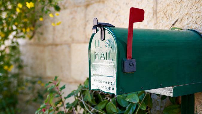 Green US post mail letter box with red flag raised up.