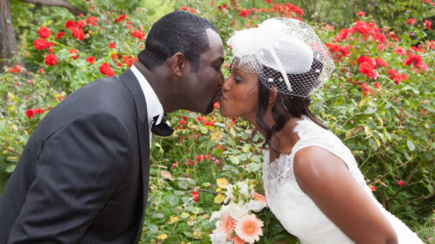 groom and bride kissing in garden
