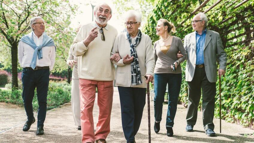 group of elderly people walking in park