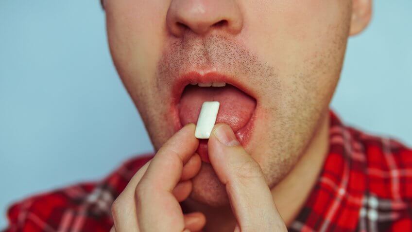 Young funny guy with chewing gum.