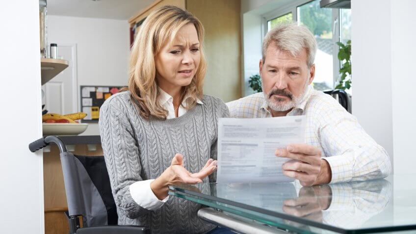 handicapped woman reviewing finances with her husband at home