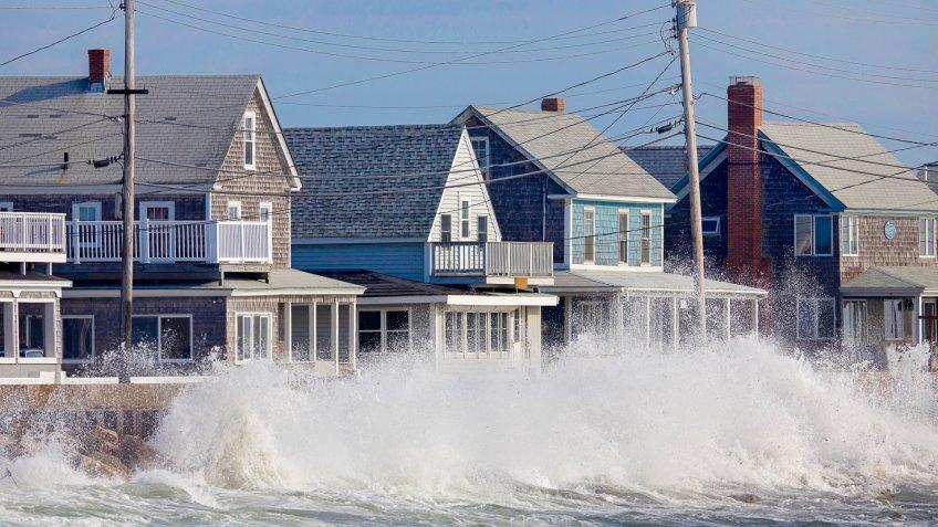 Waves crash against a break wall in conjunction with high tide and a storm.