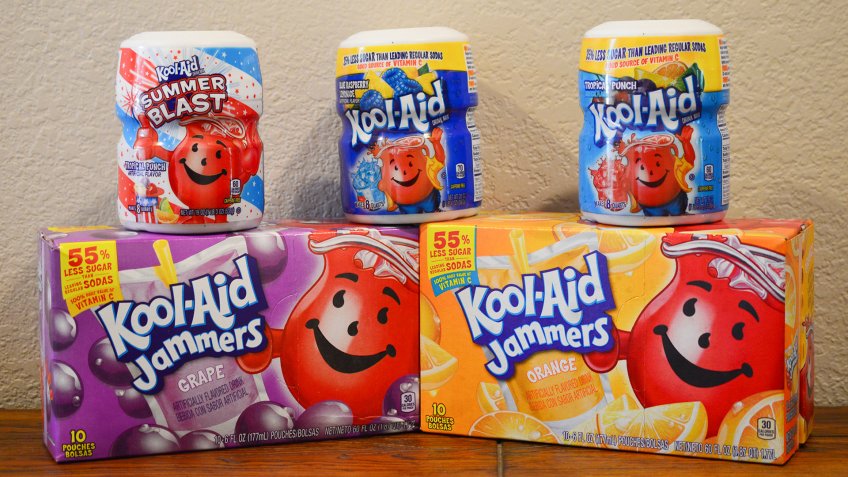 Norman, OK June 20, 2018 Close up photo of a grape and orange Kool-Aid Jammers box and three different flavors of Kool-Aid drink mixes on a wooden table with a white background.