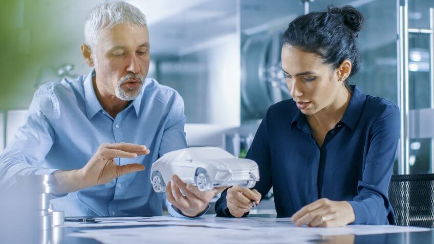 Experienced Automotive Designer and Female Engineer Works with a Concept Car Prototype Model, Perfecting it and Making Design Corrections.