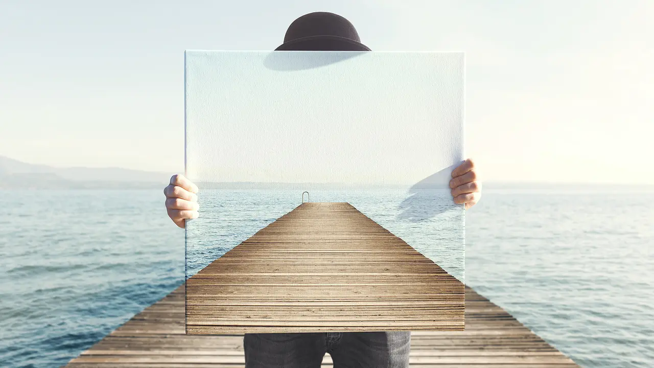 Man holding surreal painting of a boardwalk.