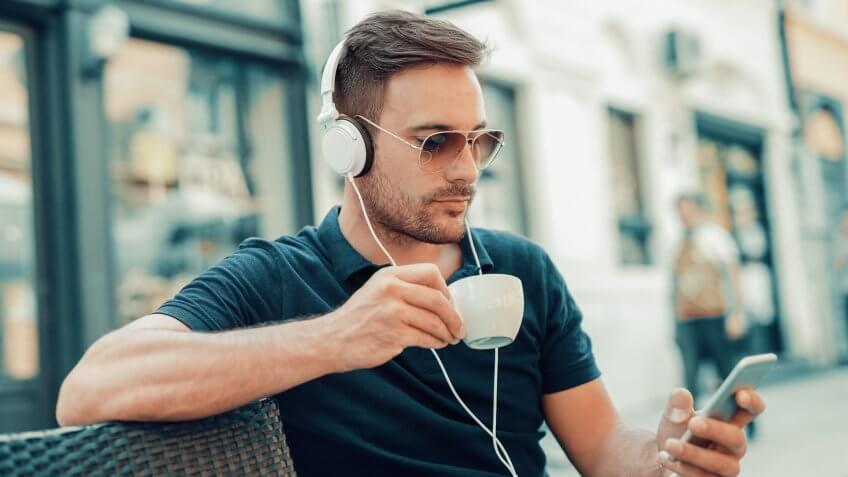 Close-up of handsome young man while listening to podcast.