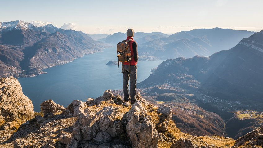 man reaching the top of the mountain