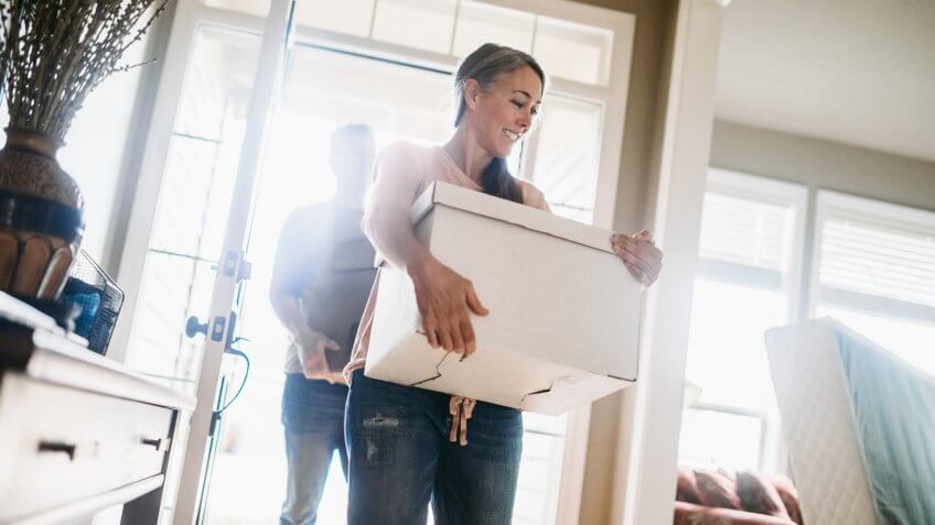 A couple in their 50's moves in to their new home, unpacking boxes and enjoying the time together.