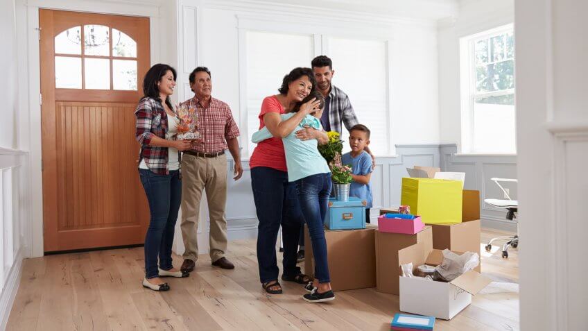 Grandparents Visiting Hispanic Family In New Home.