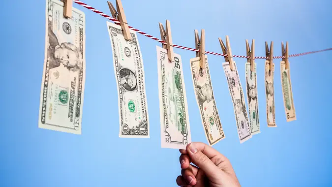 Money laundering concept shows a variety of American banknotes pegged to a clothesline.
