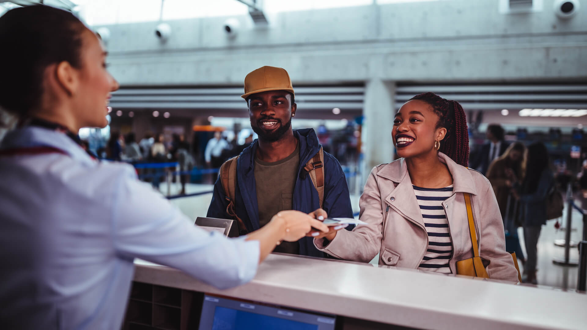 Young African-American couple doing check-in at airline check-in counter at international airport.