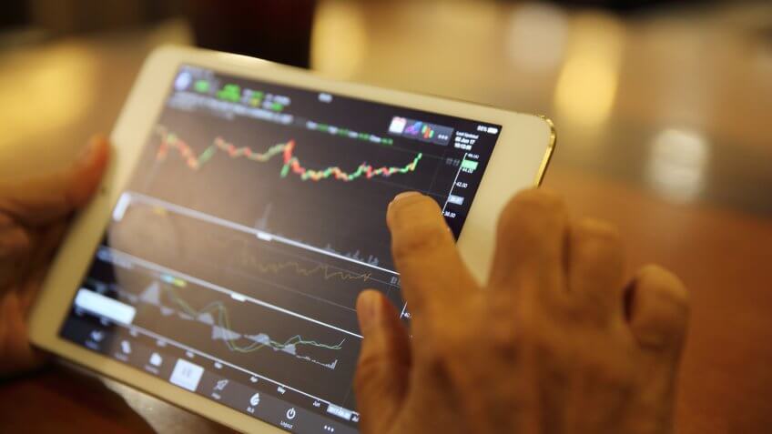 person using tablet to look at stock market