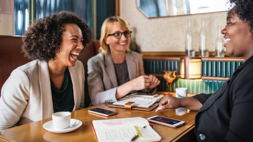 professional women laughing in a meeting