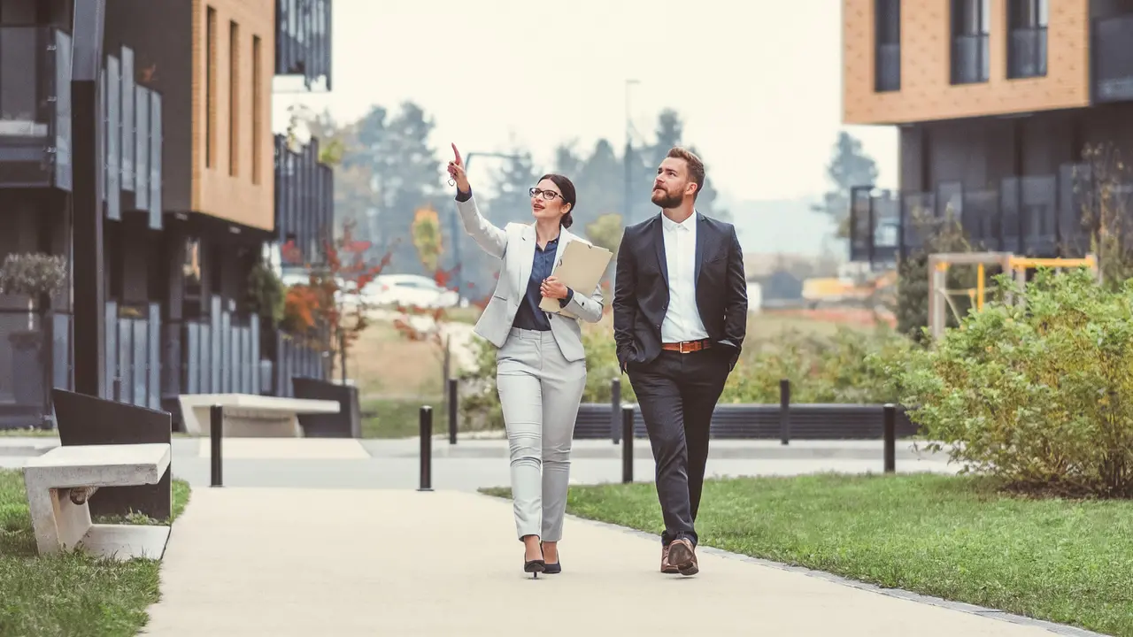 Real estate agent and businessman customer, Image taken at average residential area with multiple ownership block of flats type of buildings.