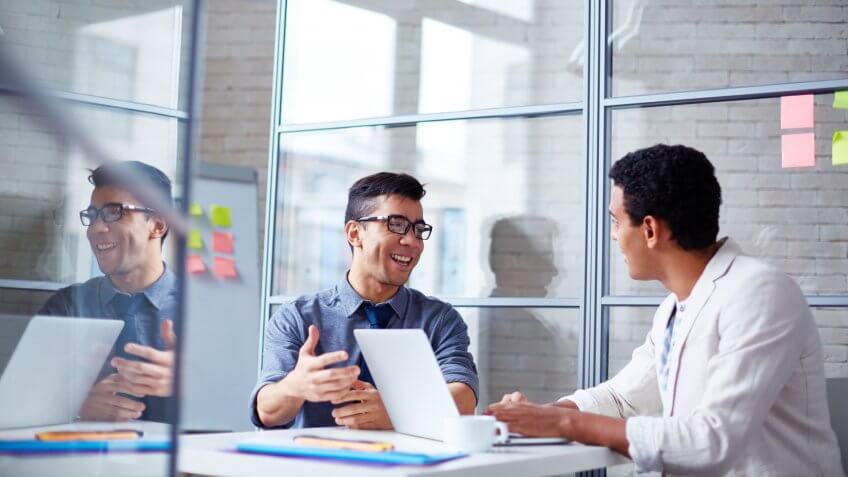 Two employees discussing data at workplace in office.