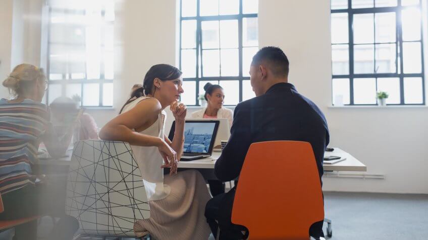 Designers talking in conference room meeting.