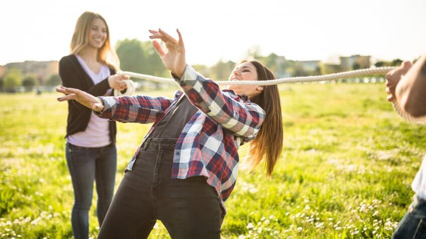 group of people playing limbo on the park.