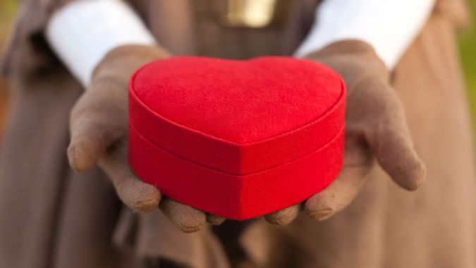 woman holding heart shape box.