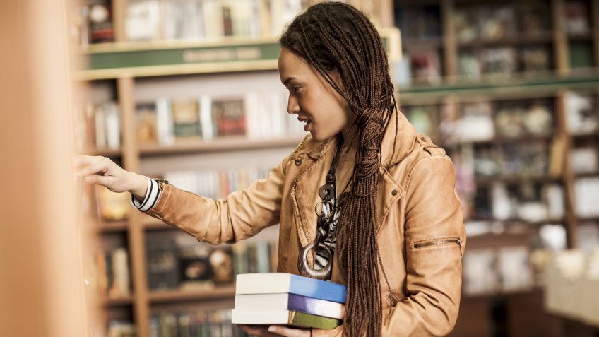 Young woman buying books at a bookstore.