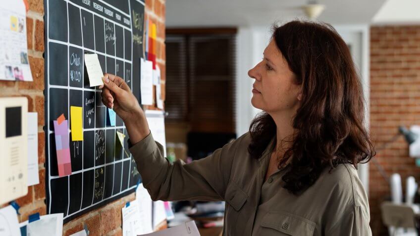 Woman pulling sticky note.