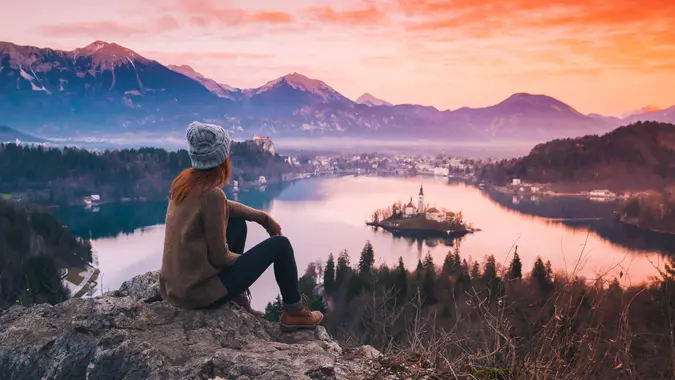 Woman looking at Bled Lake in Slovenia at sunset