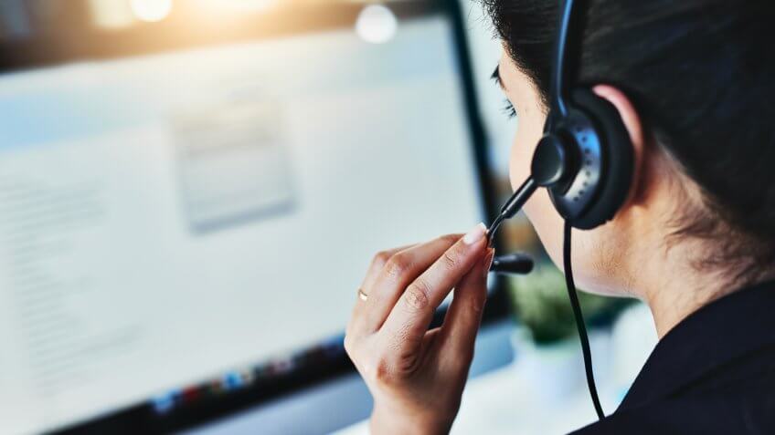 Rearview shot of a young woman working in a call centre.