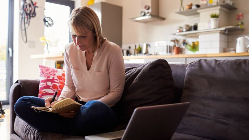 Woman Working From Home On Laptop In Modern Apartment.