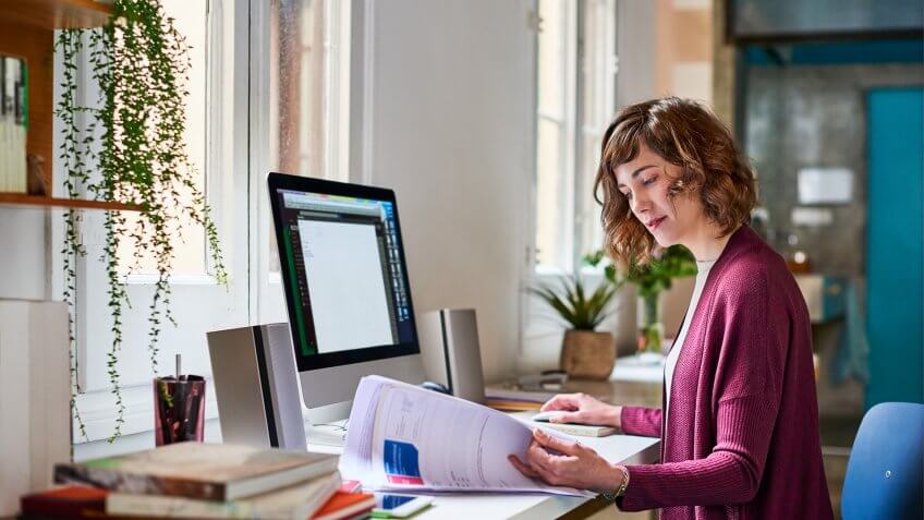 young woman working on a computer in her home office.