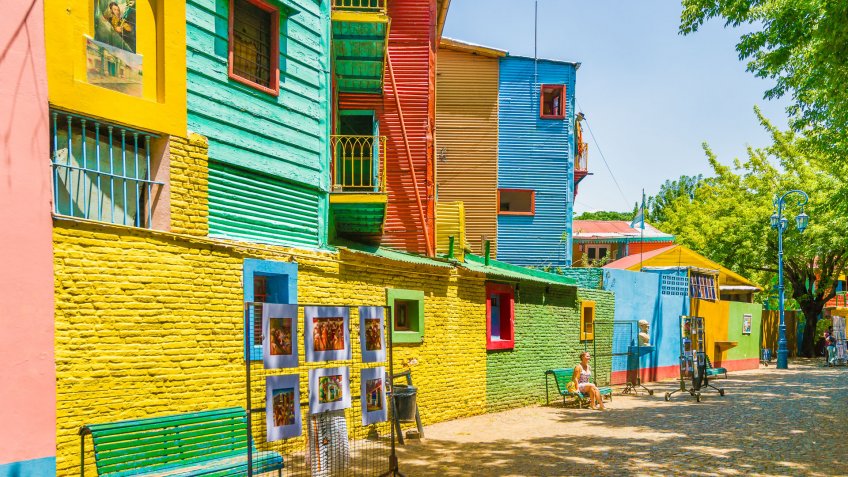 Buenos Aires, Argentina - January 30, 2013: Young woman is sitting on the bench in El Caminito, one of the most famous streets in the quarter La Boca.